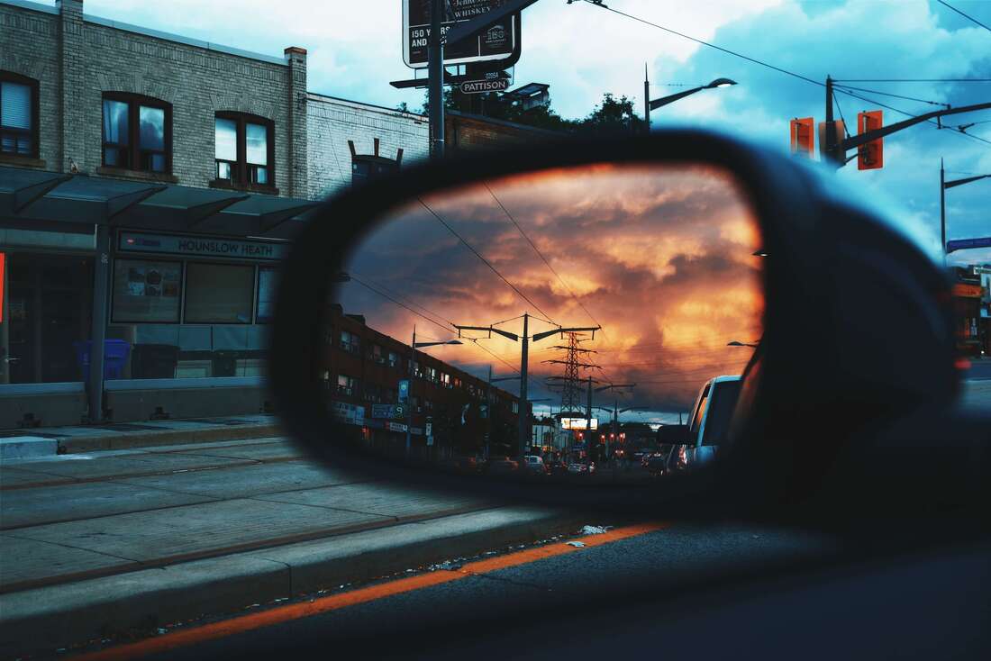 Car mirror with sunset in background